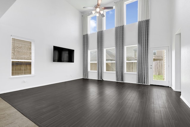 14806 Meadow Acre Trl, Houston, TX 77049 - unfurnished living room with a towering ceiling, ceiling fan, wood finished floors, and baseboards