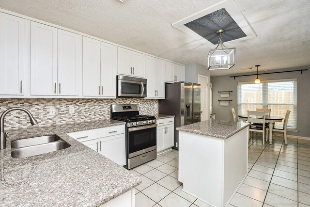 18178 Holly Green Dr, Houston, TX 77084 - kitchen with appliances with stainless steel finishes, a sink, a center island, decorative backsplash, and white cabinetry