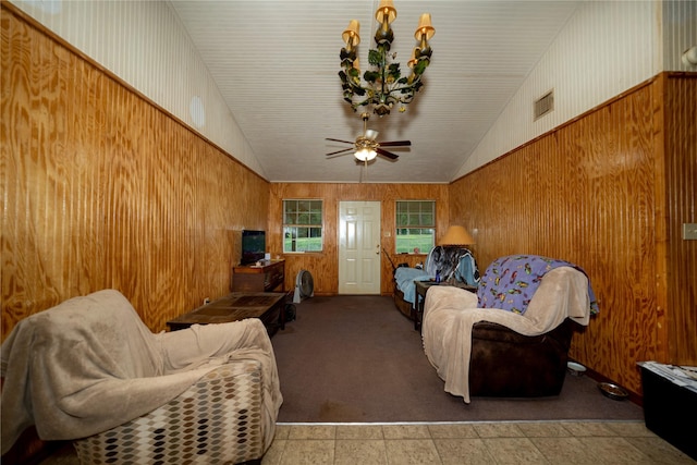5332 County Road 1180, Kennard, TX 75847 - carpeted living room with lofted ceiling, wooden walls, ceiling fan, and a chandelier