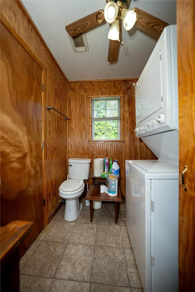 5332 County Road 1180, Kennard, TX 75847 - bathroom featuring stacked washer / dryer, toilet, a ceiling fan, and wood walls