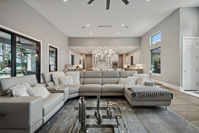 27457 S Lazy Meadow Way, Spring, TX 77386 - living area featuring a chandelier, a ceiling fan, recessed lighting, wood finished floors, and a high ceiling