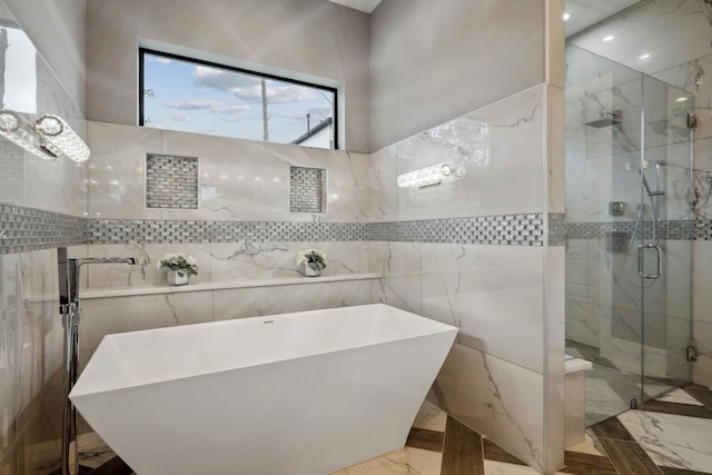 27457 S Lazy Meadow Way, Spring, TX 77386 - bathroom with marble tiled flooring, tile walls, a shower stall, a soaking tub, and recessed lighting