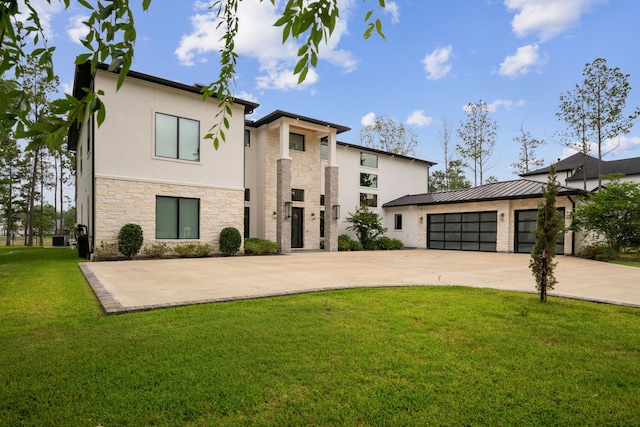 27457 S Lazy Meadow Way, Spring, TX 77386 - contemporary house with stone siding, concrete driveway, stucco siding, a front lawn, and a garage