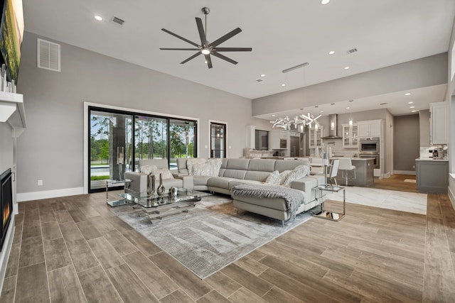 27457 S Lazy Meadow Way, Spring, TX 77386 - living room featuring ceiling fan, a lit fireplace, baseboards, recessed lighting, and a towering ceiling