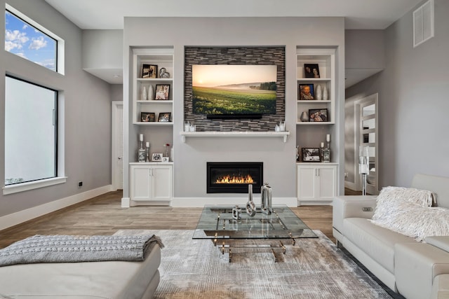 27457 S Lazy Meadow Way, Spring, TX 77386 - living room with wood finished floors, built in features, a glass covered fireplace, and baseboards