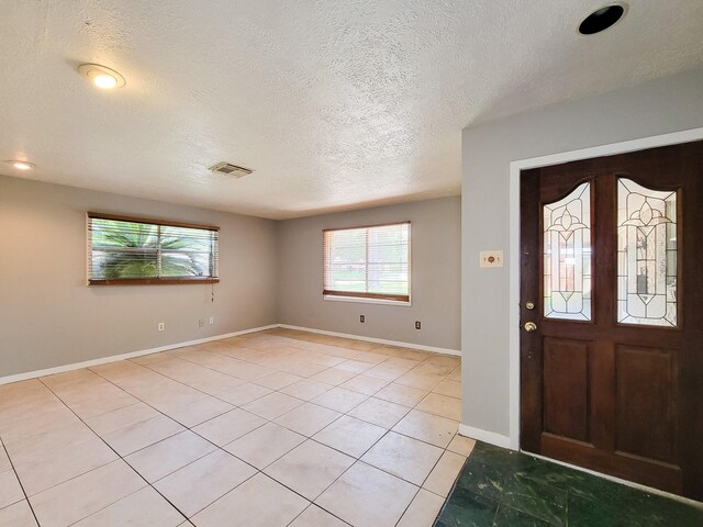1703 Raintree St, Baytown, TX 77520 - entryway featuring light tile patterned floors and a textured ceiling