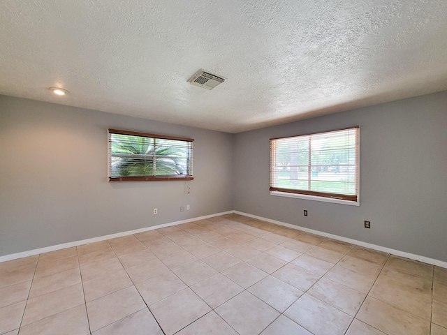 1703 Raintree St, Baytown, TX 77520 - unfurnished room with a textured ceiling, healthy amount of natural light, and light tile patterned flooring