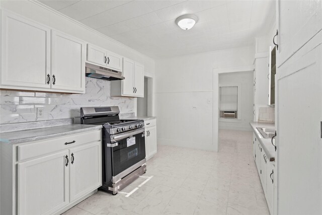 706 E Hunnicutt St, Baytown, TX 77520 - kitchen with stainless steel gas range oven, under cabinet range hood, white cabinets, and backsplash