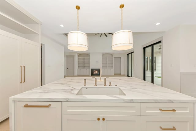 1253 Lamonte Ln, Houston, TX 77018 - kitchen featuring a sink, open floor plan, white cabinets, light stone counters, and recessed lighting