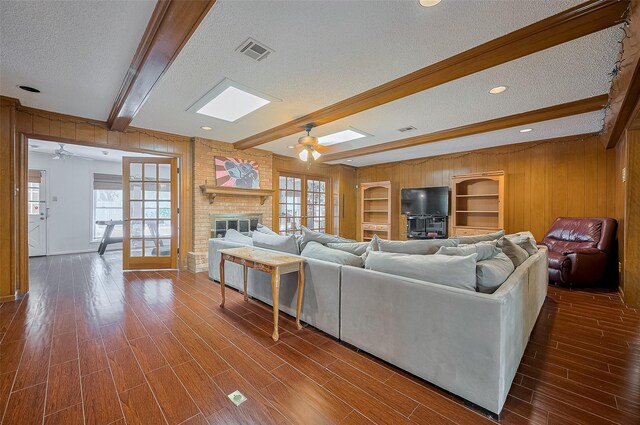 1214 Lindsey Dr, Rosenberg, TX 77471 - living room featuring ceiling fan, a textured ceiling, beam ceiling, dark wood-type flooring, and wooden walls