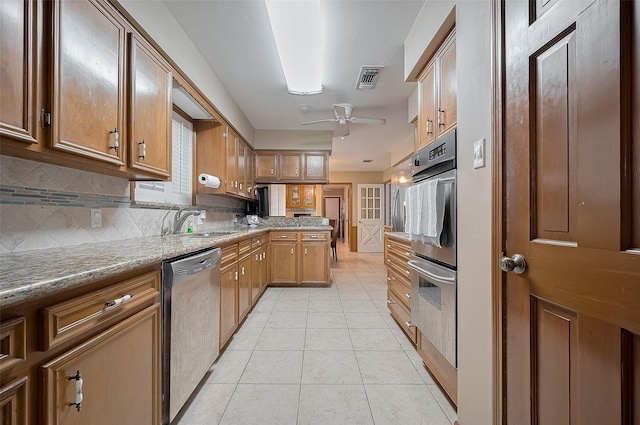 1214 Lindsey Dr, Rosenberg, TX 77471 - kitchen featuring stainless steel appliances, a sink, light tile patterned floors, a ceiling fan, and a peninsula