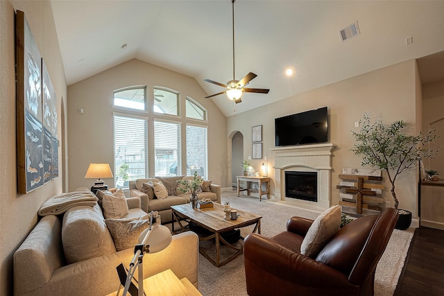 2625 Blooming Field Ln, Conroe, TX 77385 - living area featuring arched walkways, lofted ceiling, dark wood finished floors, a glass covered fireplace, and a ceiling fan