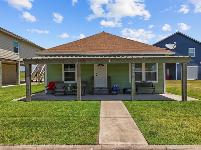 614 W 1st St, Freeport, TX 77541 - back of house featuring a shingled roof, a lawn, and covered porch