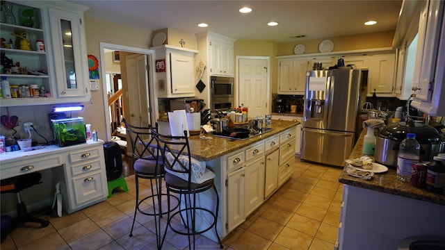 7355 Birchtree Forest Dr, Houston, TX 77088 - kitchen with stainless steel appliances, a center island, light tile patterned floors, a kitchen breakfast bar, and white cabinetry