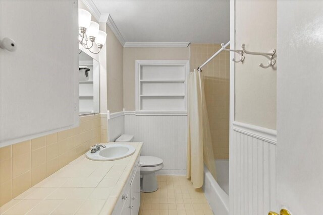 309 Helen Dr, Deer Park, TX 77536 - full bathroom featuring vanity, ornamental molding, shower / bathtub combination with curtain, tile patterned floors, and a wainscoted wall
