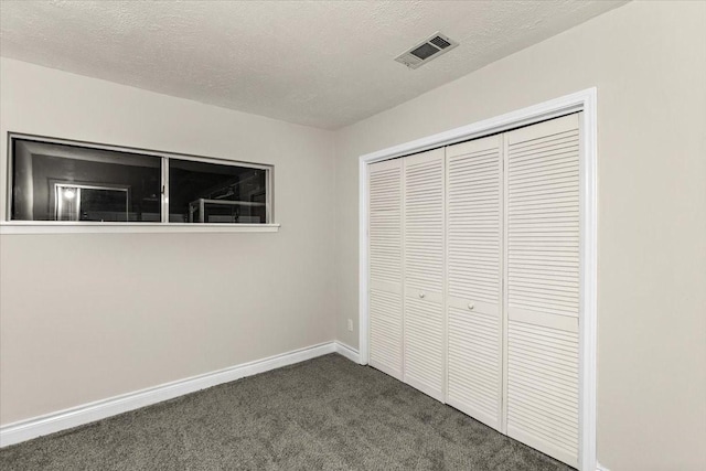 309 Helen Dr, Deer Park, TX 77536 - unfurnished bedroom with dark carpet, a closet, and a textured ceiling