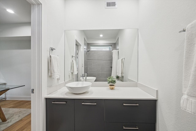 1234 W 25th St Unit A, Houston, TX 77008 - bathroom with vanity, wood finished floors, a tile shower, and baseboards
