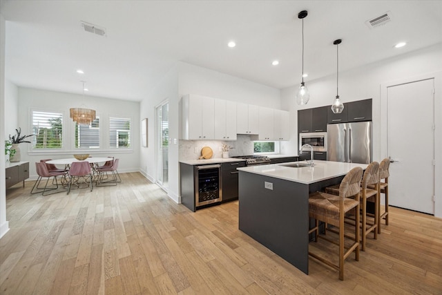 1234 W 25th St Unit A, Houston, TX 77008 - kitchen featuring beverage cooler, a sink, appliances with stainless steel finishes, light countertops, and a kitchen bar