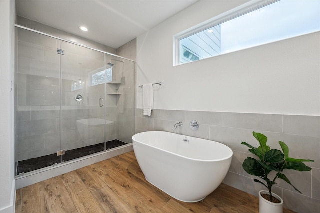 1234 W 25th St Unit A, Houston, TX 77008 - bathroom with tile walls, a shower stall, a freestanding bath, plenty of natural light, and wood finished floors