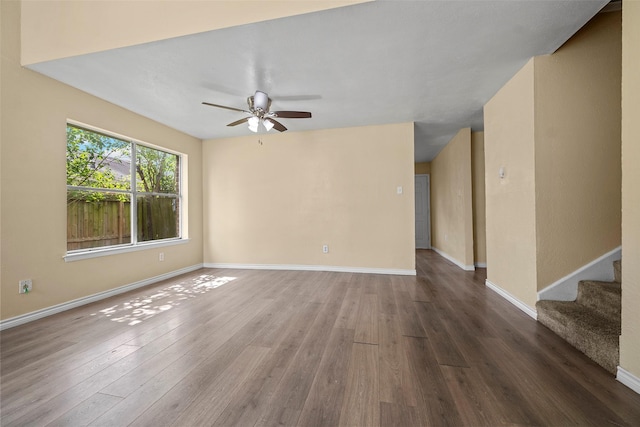 6639 Feather Creek Dr, Houston, TX 77086 - empty room with a ceiling fan, wood finished floors, baseboards, and stairs