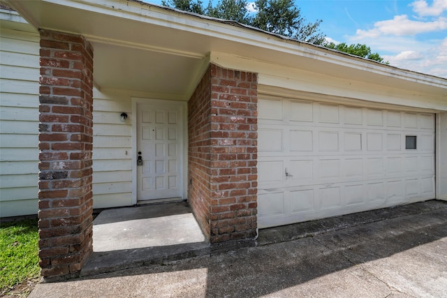 6639 Feather Creek Dr, Houston, TX 77086 - view of exterior entry with a garage and brick siding