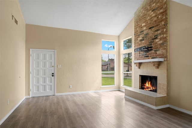6639 Feather Creek Dr, Houston, TX 77086 - unfurnished living room featuring wood finished floors, a fireplace, high vaulted ceiling, and baseboards