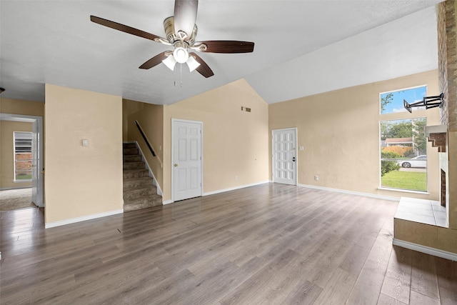 6639 Feather Creek Dr, Houston, TX 77086 - unfurnished living room with stairs, ceiling fan, wood finished floors, baseboards, and high vaulted ceiling