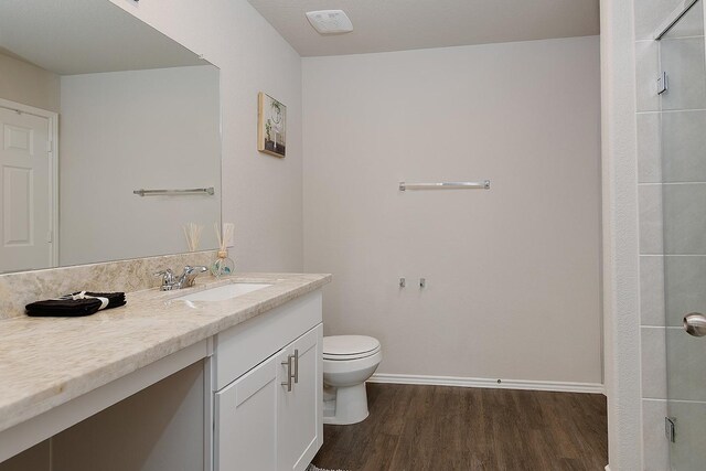 309 Cumberland Forest Dr, Magnolia, TX 77354 - full bathroom with wood finished floors, vanity, toilet, a shower with shower door, and baseboards