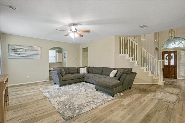 5732 Montclair Hill Ln, Rosharon, TX 77583 - living room featuring arched walkways, healthy amount of natural light, and light wood-style floors
