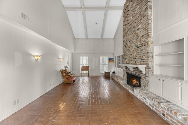 457 Monticello Park, Conroe, TX 77302 - living area featuring high vaulted ceiling, brick patterned flooring, a fireplace, beamed ceiling, and built in features