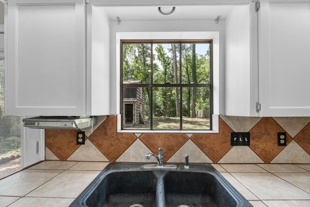 457 Monticello Park, Conroe, TX 77302 - kitchen with white cabinets, a sink, backsplash, and light tile patterned floors