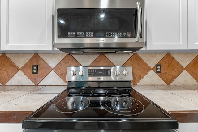 457 Monticello Park, Conroe, TX 77302 - kitchen view of stainless steel appliances, white cabinets, and tasteful backsplash