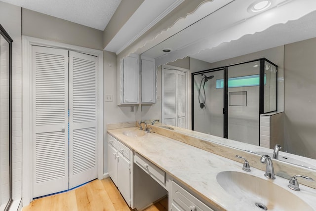 457 Monticello Park, Conroe, TX 77302 - bathroom with a closet, double vanity, a stall shower, and wood finished floors