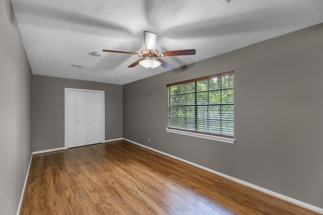 457 Monticello Park, Conroe, TX 77302 - unfurnished bedroom featuring wood finished floors, baseboards, and a textured ceiling