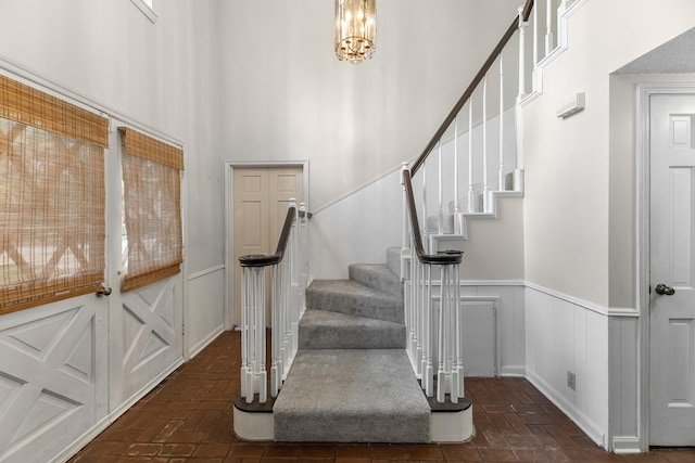 457 Monticello Park, Conroe, TX 77302 - foyer entrance featuring brick floors, stairway, wainscoting, a chandelier, and a decorative wall