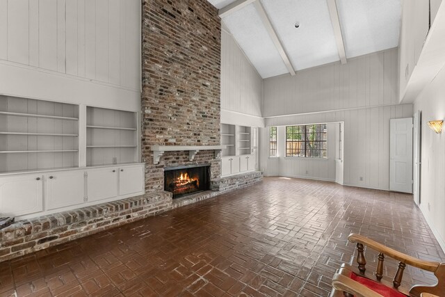 457 Monticello Park, Conroe, TX 77302 - unfurnished living room with high vaulted ceiling, built in features, brick patterned flooring, a fireplace, and beam ceiling