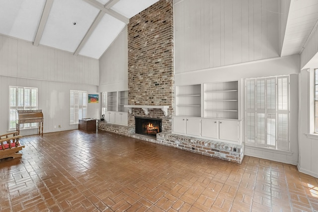 457 Monticello Park, Conroe, TX 77302 - unfurnished living room featuring high vaulted ceiling, built in features, a fireplace, baseboards, and beamed ceiling
