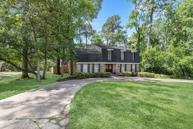 457 Monticello Park, Conroe, TX 77302 - dutch colonial featuring brick siding, a front lawn, and a shingled roof