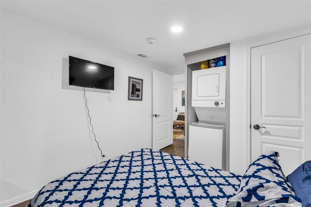 7112 Ave L, Houston, TX 77011 - bedroom with stacked washing machine and dryer, wood finished floors, and baseboards