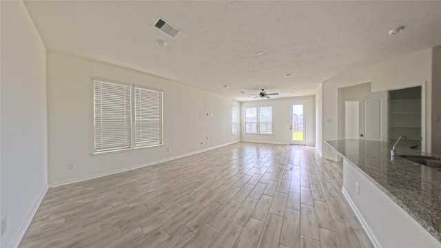 4322 Mossy Banks Ln, Houston, TX 77068 - unfurnished living room with a sink, light wood-style floors, a ceiling fan, and baseboards