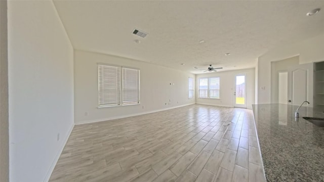 4322 Mossy Banks Ln, Houston, TX 77068 - empty room with baseboards, ceiling fan, light wood-style flooring, and a sink