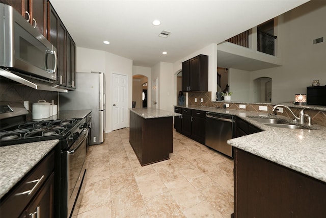 3314 Tall Sycamore Trl, Katy, TX 77493 - kitchen with stainless steel appliances, arched walkways, a sink, light stone countertops, and tasteful backsplash