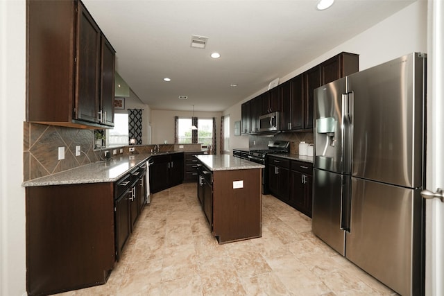 3314 Tall Sycamore Trl, Katy, TX 77493 - kitchen with appliances with stainless steel finishes, dark brown cabinetry, decorative backsplash, a center island, and recessed lighting
