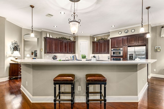 212 Salmon Creek Ln, Friendswood, TX 77546 - kitchen featuring appliances with stainless steel finishes, dark wood-type flooring, light countertops, dark brown cabinetry, and recessed lighting