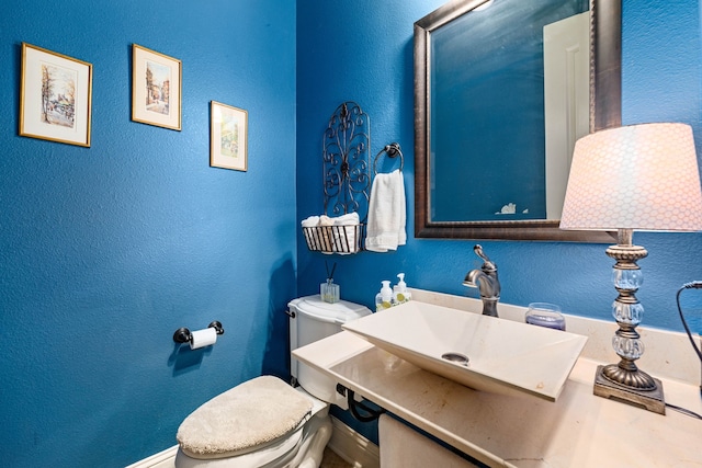 212 Salmon Creek Ln, Friendswood, TX 77546 - half bath with toilet, a sink, a textured wall, and baseboards