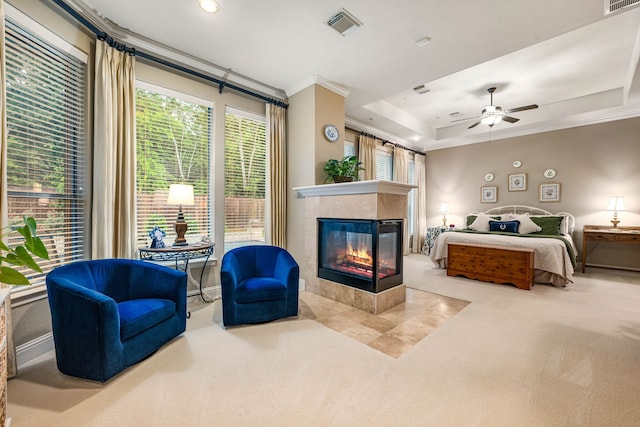 212 Salmon Creek Ln, Friendswood, TX 77546 - carpeted bedroom with ornamental molding, a tiled fireplace, a ceiling fan, and a tray ceiling