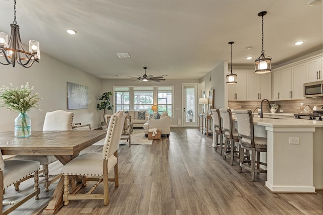 109 Pepper Grass Pl, Montgomery, TX 77316 - dining space with wood finished floors, a ceiling fan, recessed lighting, a chandelier, and baseboards
