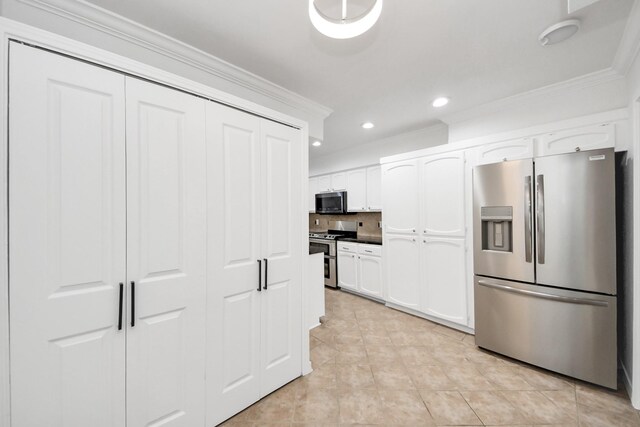 405 N Post Oak Ln Unit 405, Houston, TX 77024 - kitchen with stainless steel appliances, ornamental molding, white cabinetry, recessed lighting, and light tile patterned floors