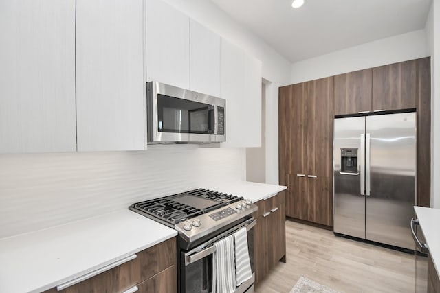 4020 Boho Ln, Houston, TX 77045 - kitchen featuring appliances with stainless steel finishes, modern cabinets, light countertops, decorative backsplash, and recessed lighting