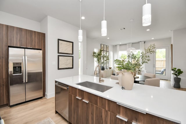 4020 Boho Ln, Houston, TX 77045 - kitchen with stainless steel appliances, a sink, modern cabinets, light wood finished floors, and recessed lighting